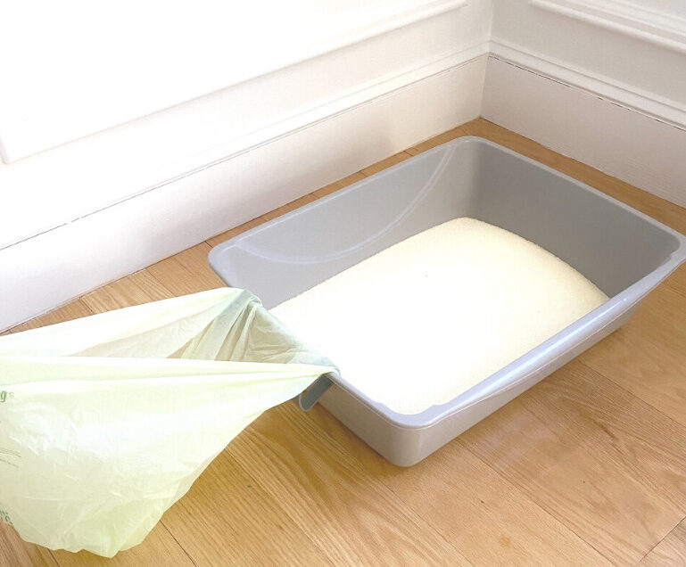 Waste bag is secured onto the cat litter box using Scoop Buddy clips